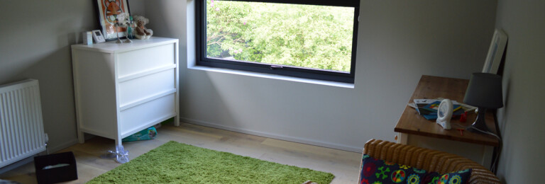 Nursery room with feature window in renovated 1960s property