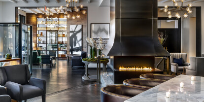 The H Series fireplace by European Home: a 3-sided linear fireplace paired with a custom steel vent hood creates a stunning statement in the St. Gregory hotel lobby.