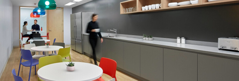 Informa’s communal kitchen features splashes of colour from the Knoll furnishings and Kartell light fixtures, complementing the neutral grays of the AyA cabinetry and Caesarstone countertop.