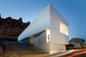 House on mountainside overlooked by castle