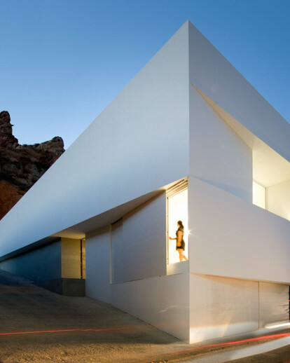 House on mountainside overlooked by castle