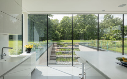 Double height, triple glazed glass walls in contemporary new build.