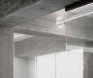 A lighting element traverses the concrete beam.