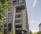 The northwest corner of the building features a 6-story sculpted glass façade that animates the corner as a brightly lit lantern.