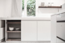The white colour gives the concrete kitchen a certain lightness