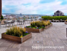 DeepStream's custom cost-effective, multi-section commercial wood planters create the landscaping foundation for an exclusive building amenity high above Boston’s harbor without requiring roof penetrations.