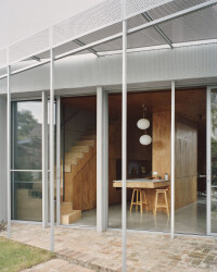 Perforated steel sunshading along the length of the rear verandah provides sun control in summer while still allowing passive heat gain in winter.