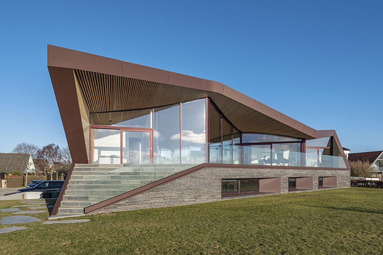 Inhabitable sculpture wrapped in an undulating roof frames Danish ocean views