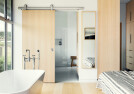 Bathroom entry in master suite featuring Oden Top Mount sliding door system from Krownlab