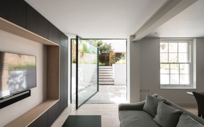 Oversized glass pivot door solution to contemporary extension.