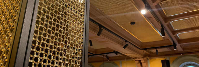 Banker Wire M22-83 Brass wire mesh installed as ceiling tile and TXZ-3 Braided Brass wire mesh installed as wall decor for Beirut Café in Stockholm Sweden