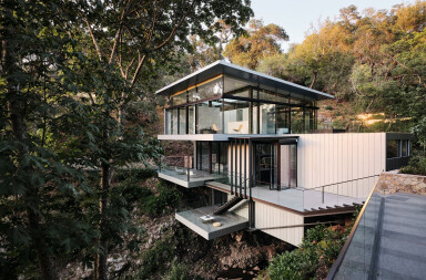 Suspension House by Fougeron Architecture dramatically spans a creek and waterfall running between lush California hills
