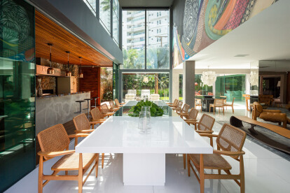 Mesa de jantar com cadeiras Oscar, do designer Sérgio Rodrigues, compõe este espaço amplo e plenamente integrado com o living, gourmet e varandas exteriores