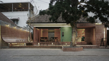 A signature ergonomically curved brick wall defines the Mutu Loka cafe in Bandung, Indonesia