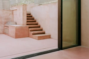 Dusty pink pigmented concrete defines the characterful terraced landscape of Pigment House