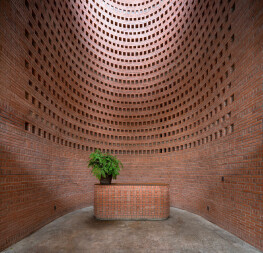 A serene brick-covered office building in Ho Chi Minh City features a temple-like void