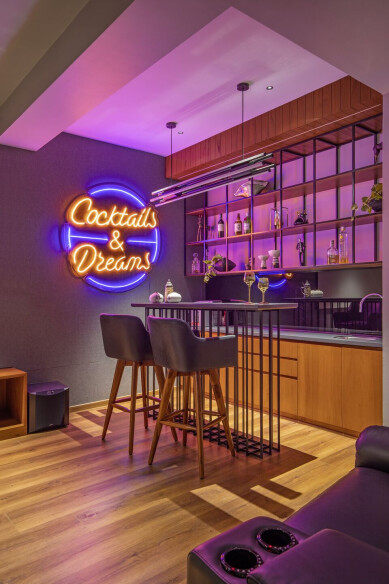 The bar table is cast out of the stone top and metal framing and the bar unit is in Veneer finish and Metal frame – niches. The LED installation of ‘Cocktails and Dreams’ in the backdrop adds glory to the bar.