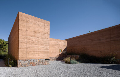View of gravel courtyards, stone foundations and rammed earth walls of communal dwelling and gathering spaces