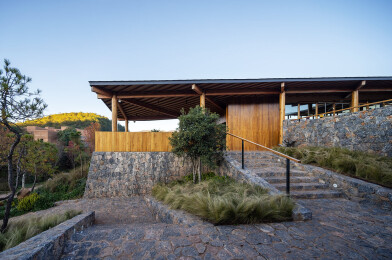 Trail entry to traditionally timbered public cultural facilities structured on stone plinth