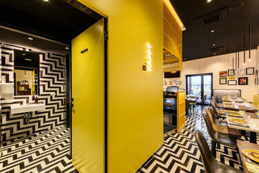 Yellow cube with yellow coated metal grid that encloses the bar area and services