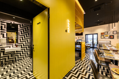 Yellow cube with yellow coated metal grid that encloses the bar area and services