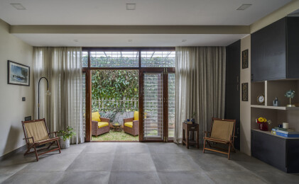 The natural material finishes in the interiors is completed by the landscaping visible through the large french doors.