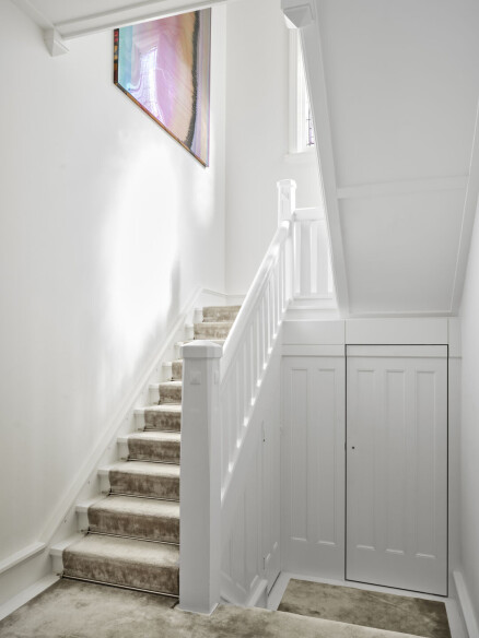 The powder room is concealed under the stairs
