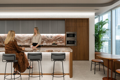 The kitchen utilises the project colour palette including warm timbers, rusted oranges and bronzed metals and provides a space for breaks and casual engagement.