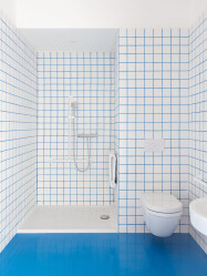 A playful use of white tiles and colored grout that matches the floor color.