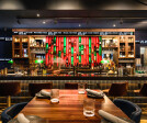 Elegant yet inviting, this bar area exudes contemporary charm with its vibrant backlit shelving highlighting an array of spirits.