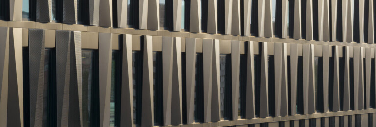 The façade shifts from black to white, silver, and gold, depending on the changing daylight.