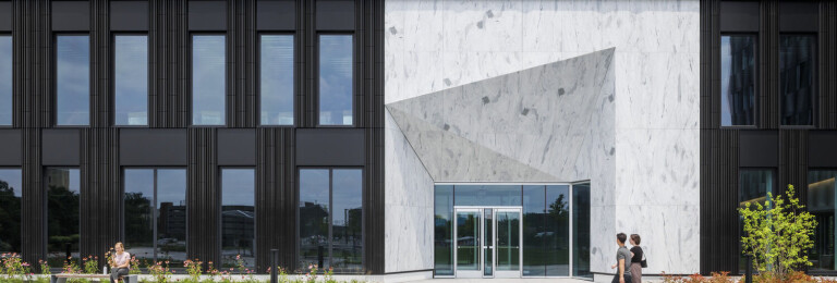 A change in texture and material marks the building's entrance.