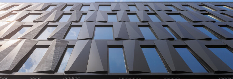 Like the metal panels, the building's windows mirror the sky.