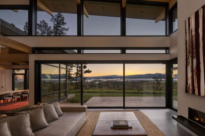 The double-height great room provides well-proportioned living space while framing extraordinary mountain views.