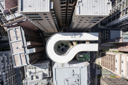 Aerial view. The distorted U-shaped volume creates space between it and the adjacent buildings.